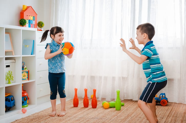 two children playing an indoor ball game together