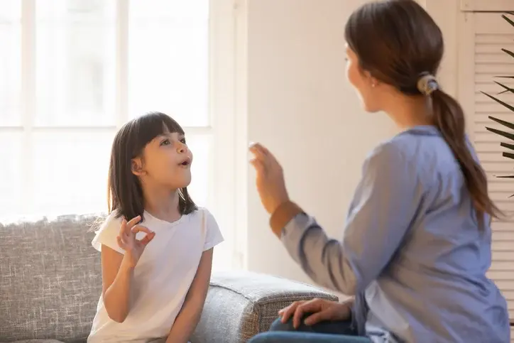 An ABA therapist and child working together in an imitation drill using ARIS materials